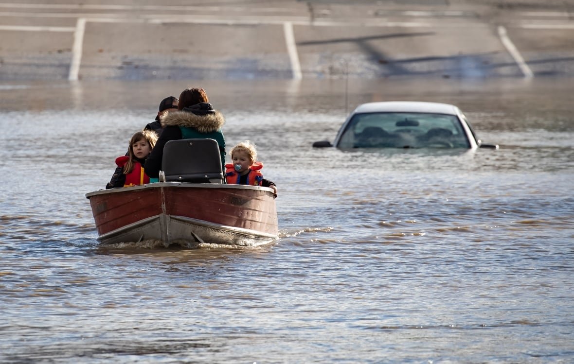 A woman and children who were stranded by high water due to flooding are rescued in Abbotsford, B.C., on Tuesday, Nov.16, 2021.