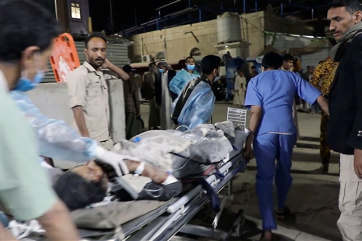 An injured person on a stretcher rushed by paramedics to a hospital.