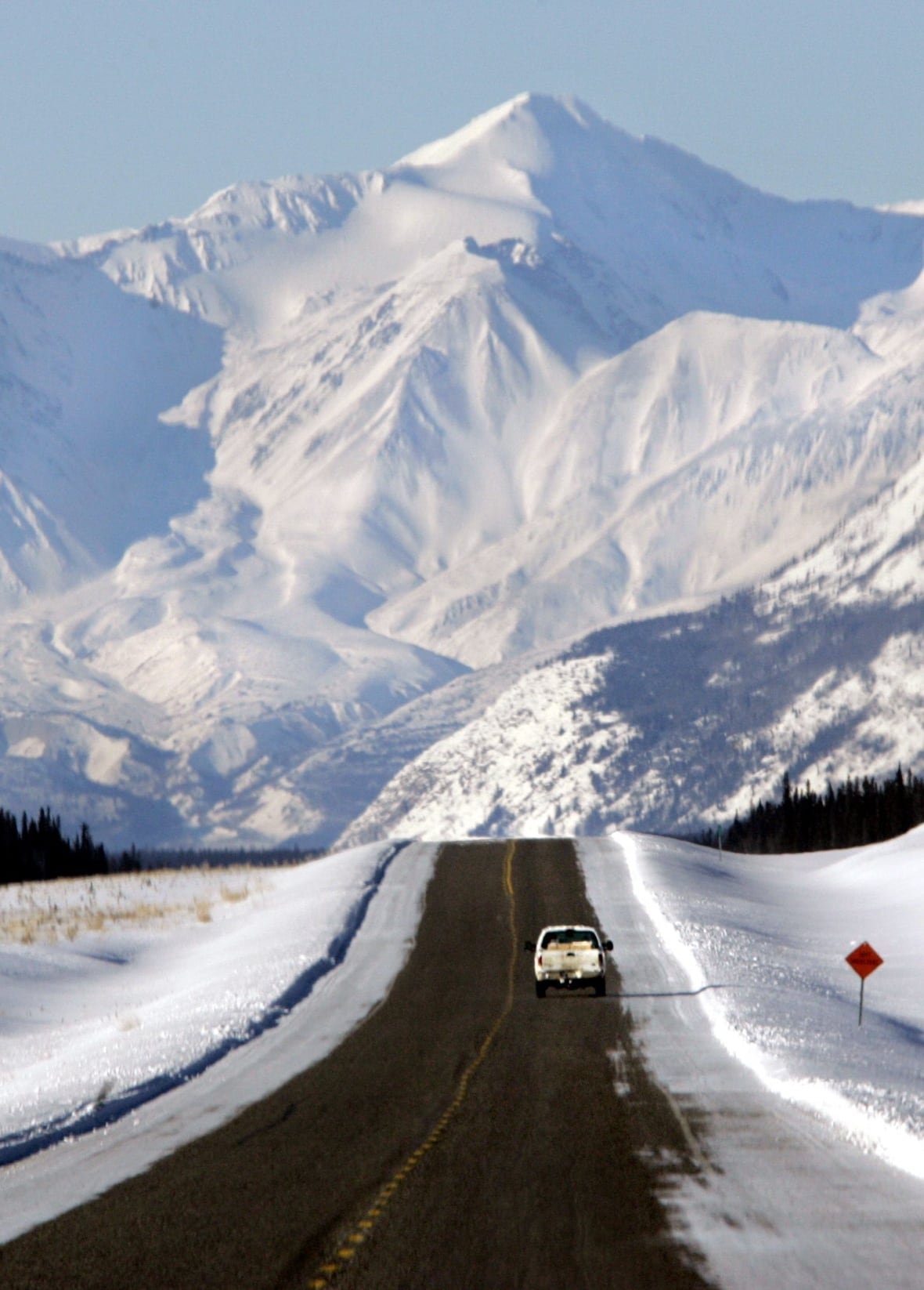 A truck on a snowy mountain highway.
