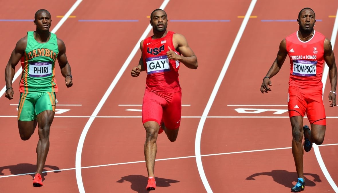 149787856 Three sprinters cross the finish line during a race.