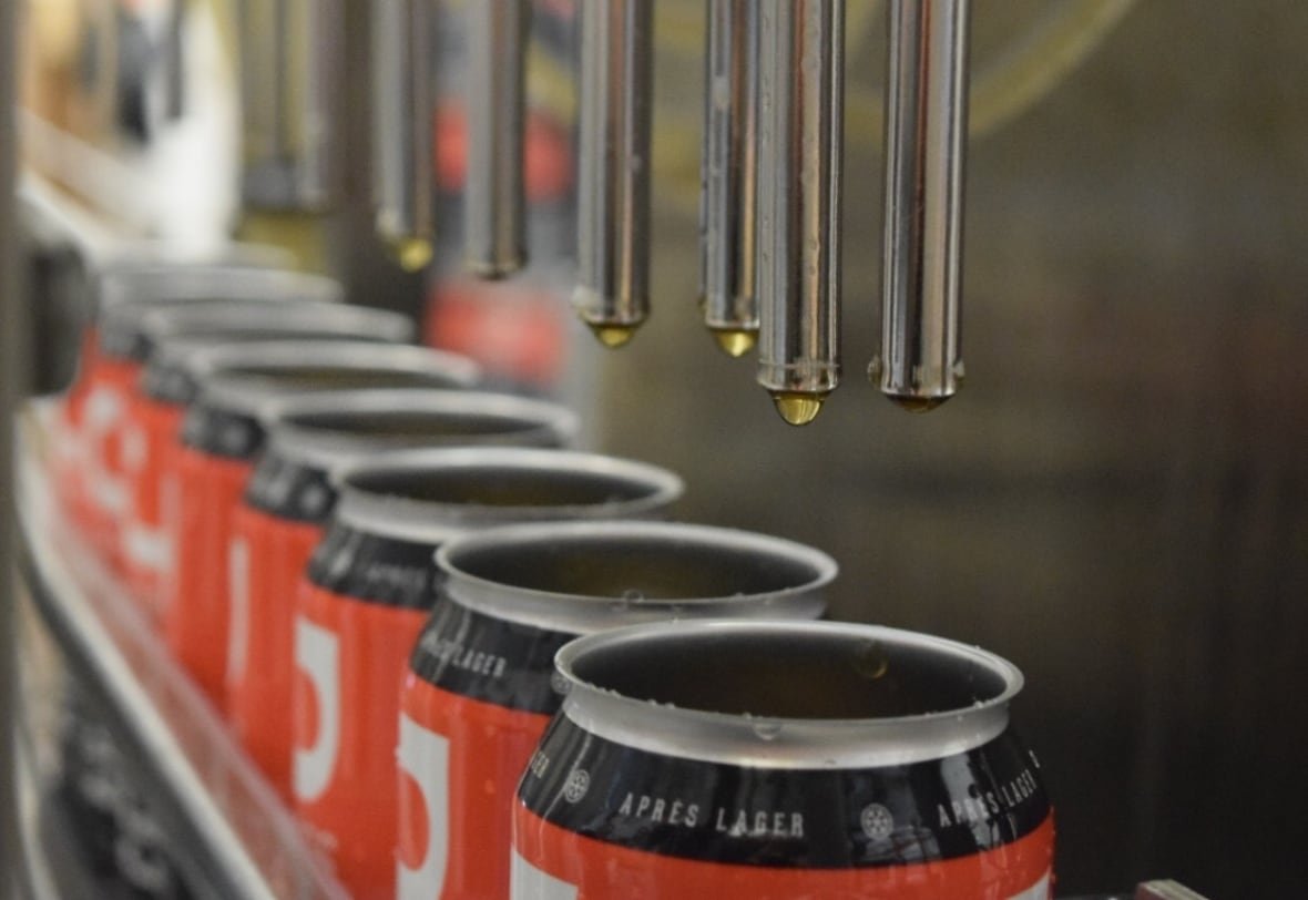 aluminum-cans Tall boy cans being filled with liquid on an assembly line