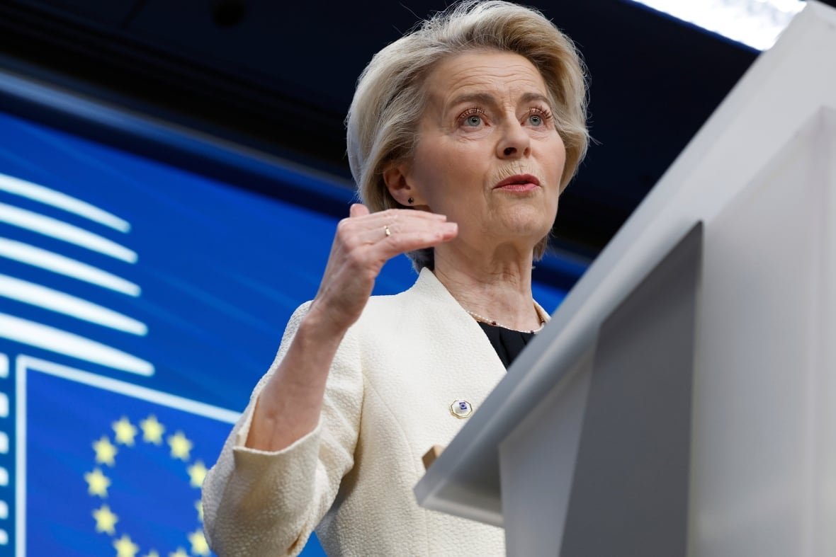 europe-nato A woman stands at a podium with the European Union flag behind her.