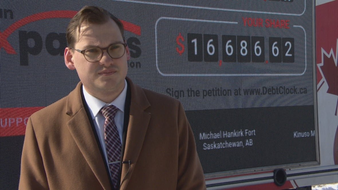 gage-haubrich-canadian-taxpayers-federation Man standing in front of a digital debt clock