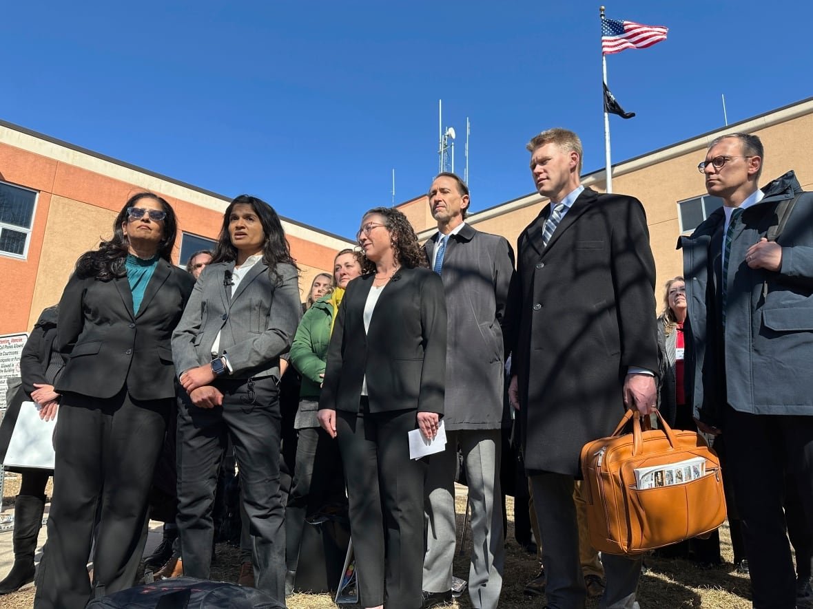 A group of people in suits in front of a building