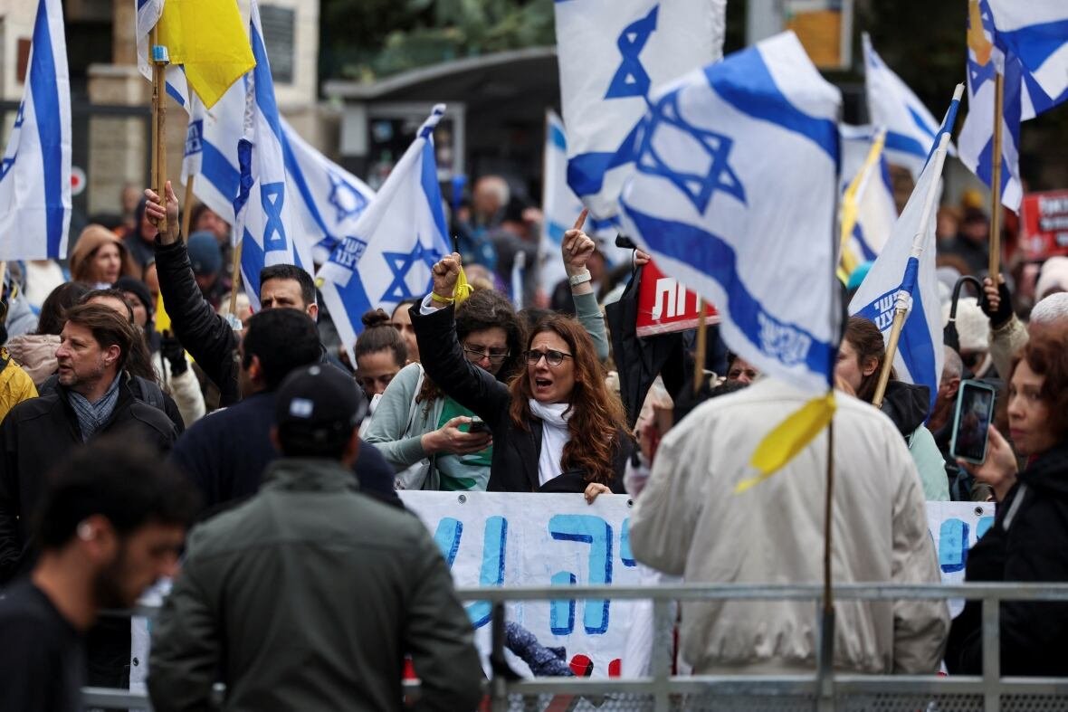 israel-palestinians-netanyahu-protests People holding Israeli flags at a protest.