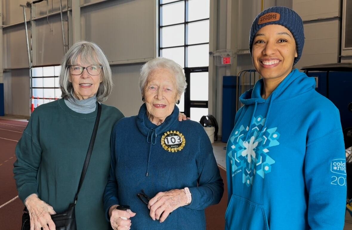 three women smiling at an indoor track