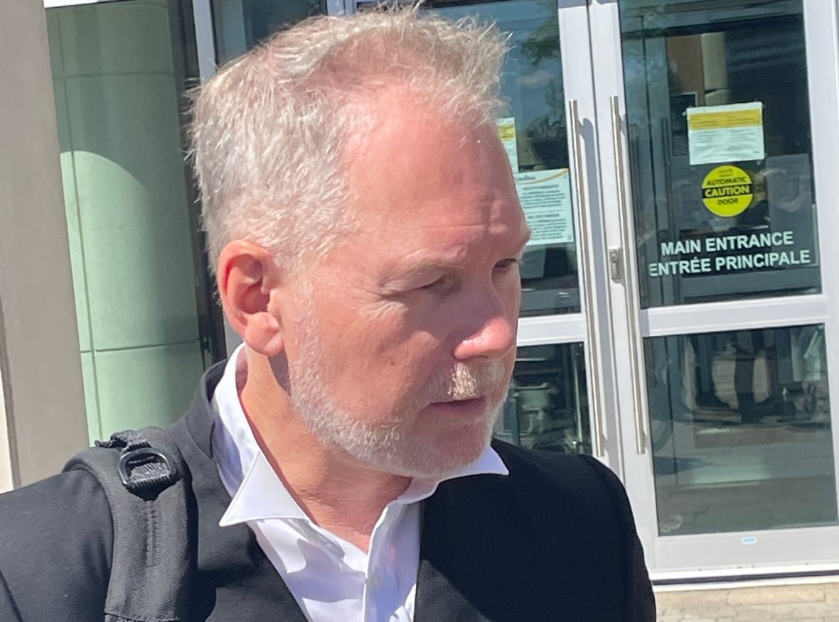 plaintiffs-lawyer-john-mckiggan The profile of a man with grey hair and a beard, wearing a white shirt and black blazer.