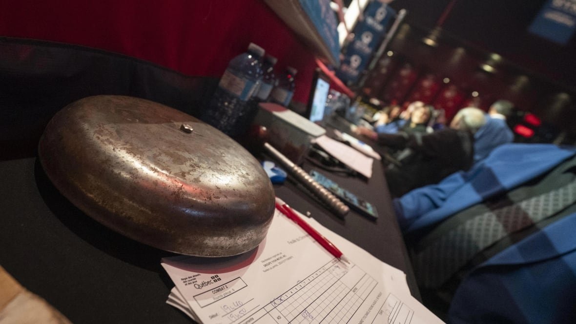ringside-boxing-quebec-montreal-jeanette-zacarias-zapata A ringbell and a table outside a boxing ring.