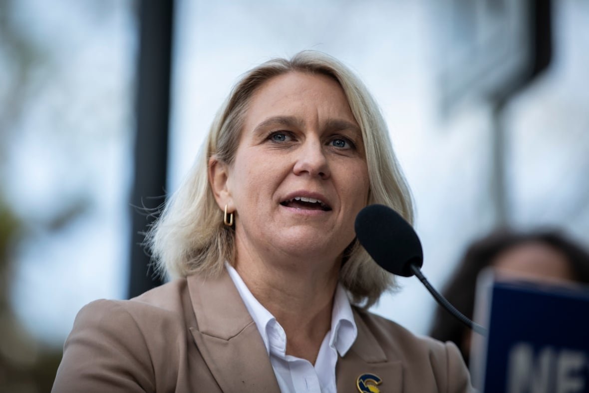 rustad-womens-health-election-elenore-sturko A white woman with white-blond hair speaks into a mic.