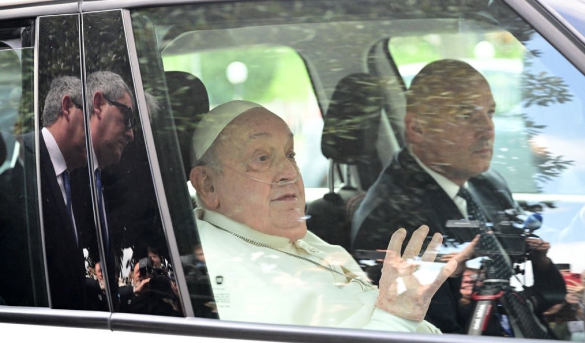 2205907045 Pope Francis sits in a car and waves.