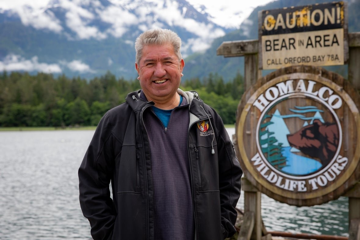 chief-darren-blaney A smiling Indigenous man with white hair stands on a dock.