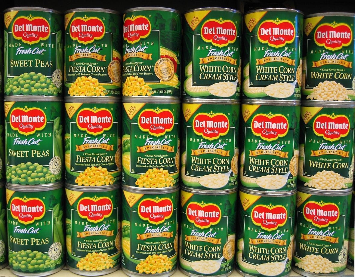 earns-del-monte-foods Rows of canc of vegetables with brand logo Del Monte