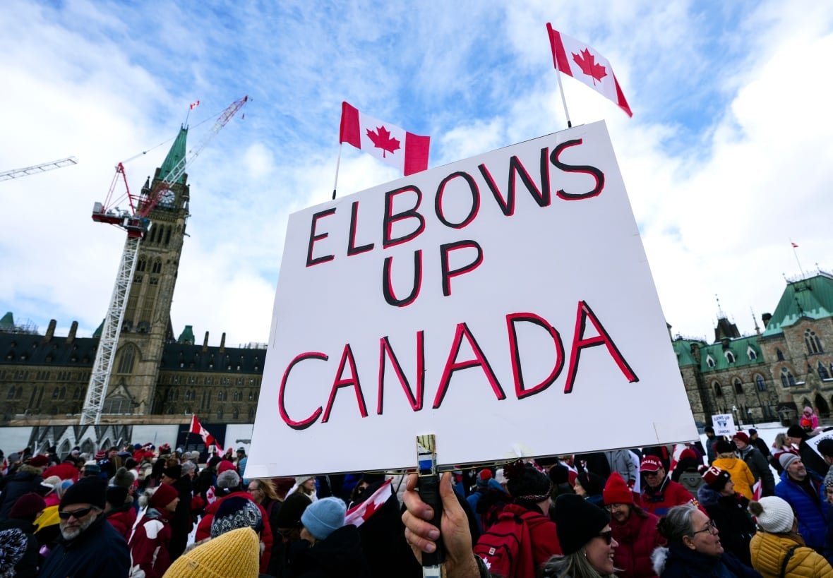 elbows-up-canada-rally-20250309 A protester holds up a sign that reads, 'Elbows up Canada,' during a rally.