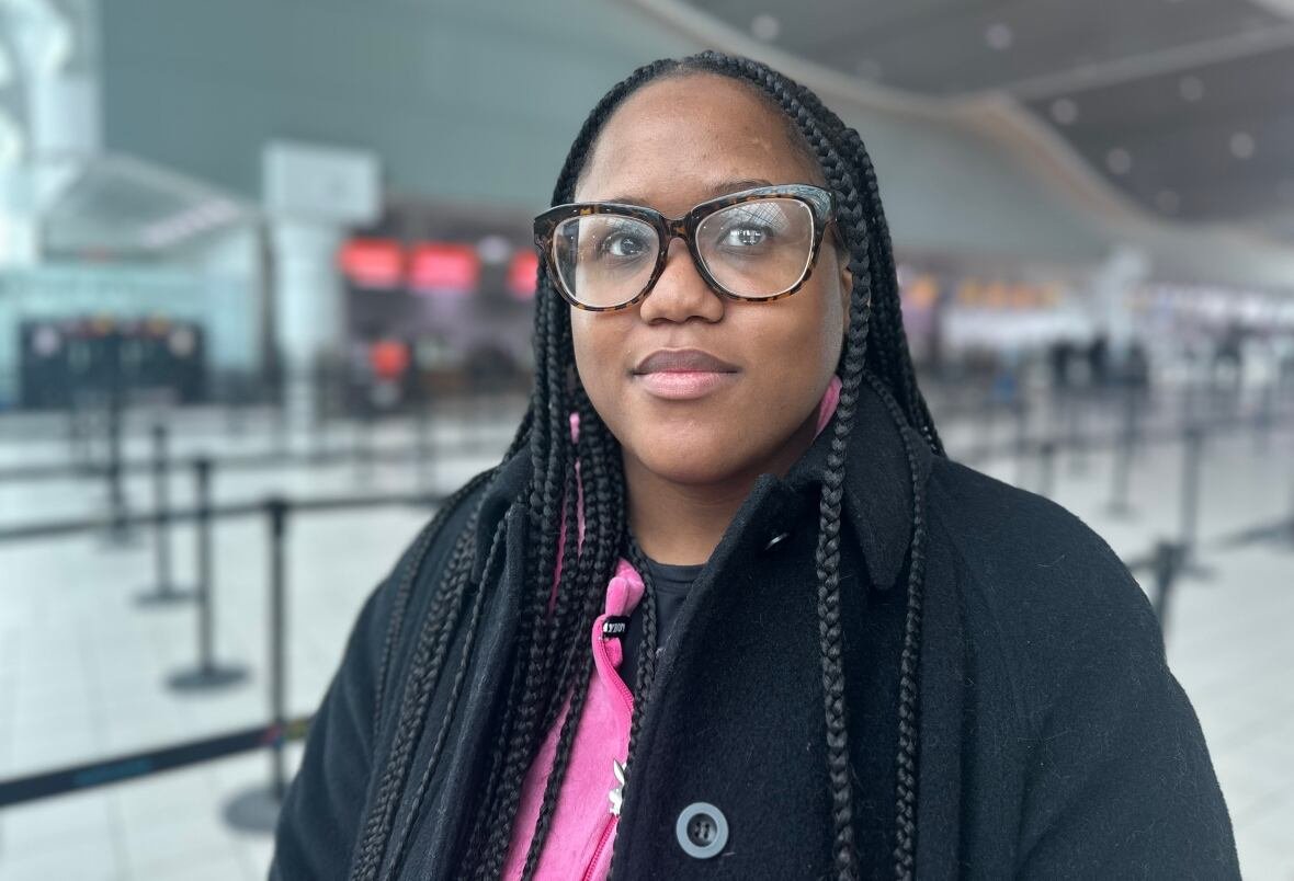 iesha-williams-1 A woman stands in an airport looking annoyed