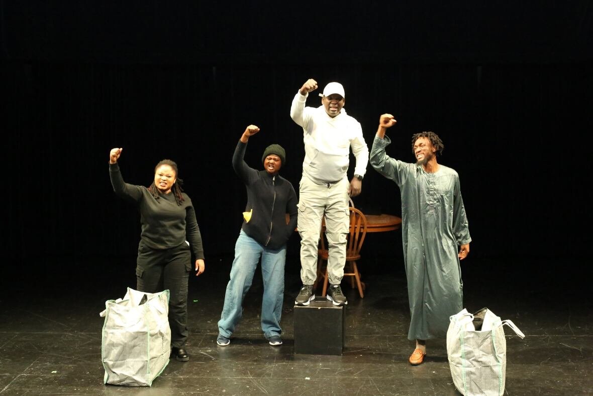 off-guard Four Black actors stand on a stage, each raising a fist in the air.