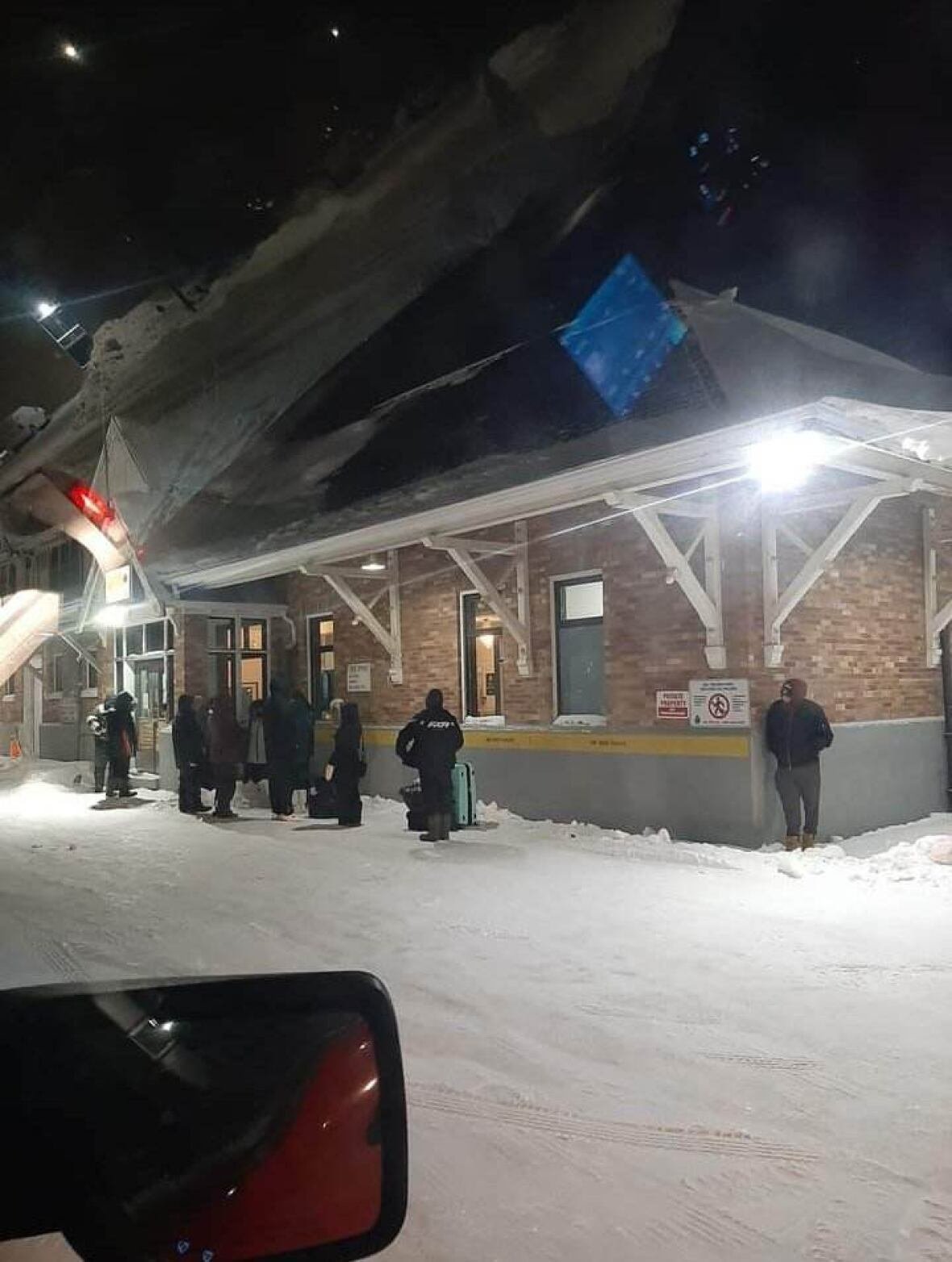 train-station-line-up-in-the-pas-1 People dressed warmly line up in the early morning cold outside a train station in The Pas.