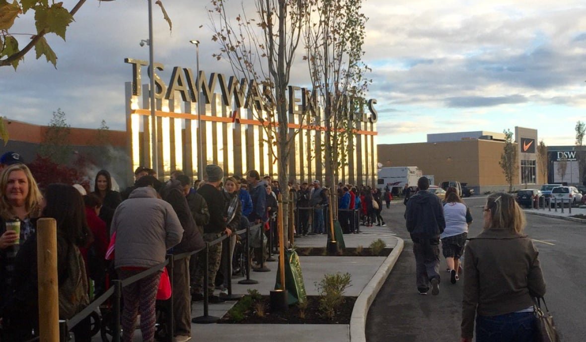 tsawwassen-mills-mall-opening A lineup of people outside a large mall with a sign reading 'Tsawwassen Mills.'