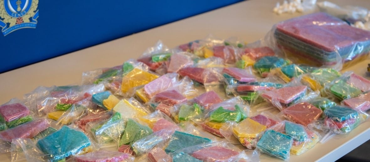 regina-police-fentanyl Packages of a colourful substance are displayed on a table.