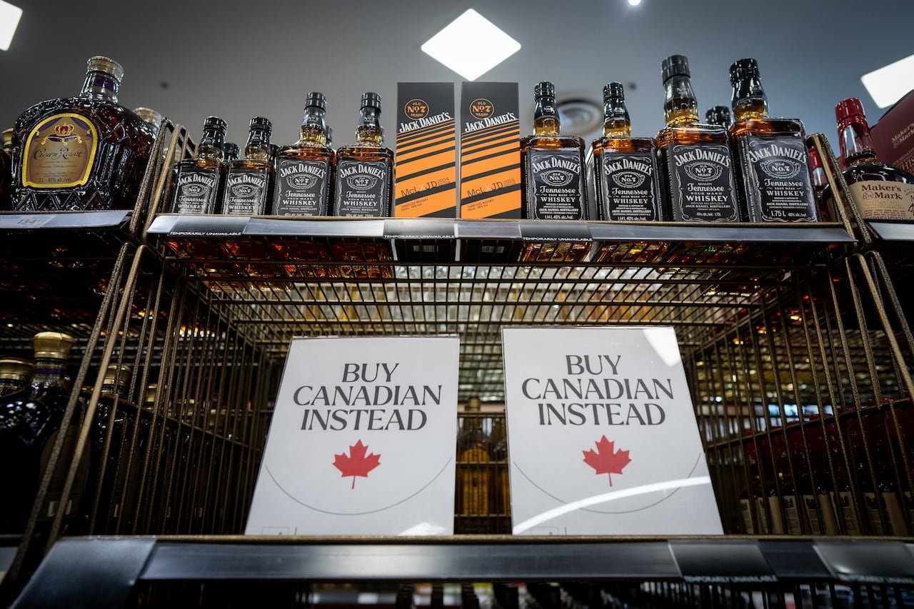 default-386 A sign that says "Buy Canadian Instead" is shown at a liquor store besides some American-made products.