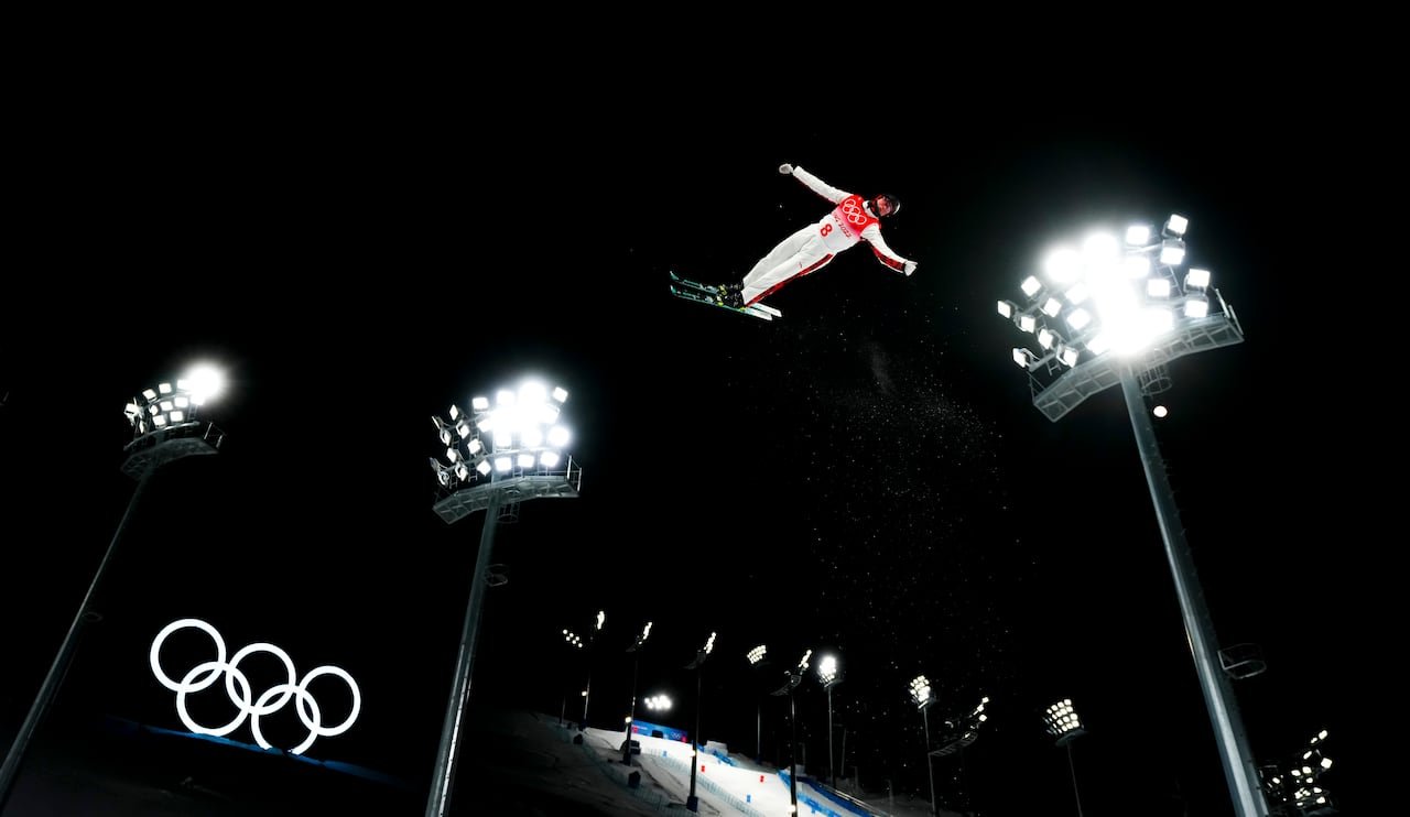 default-216 An aerials skier performs above the Olympic rings logo.