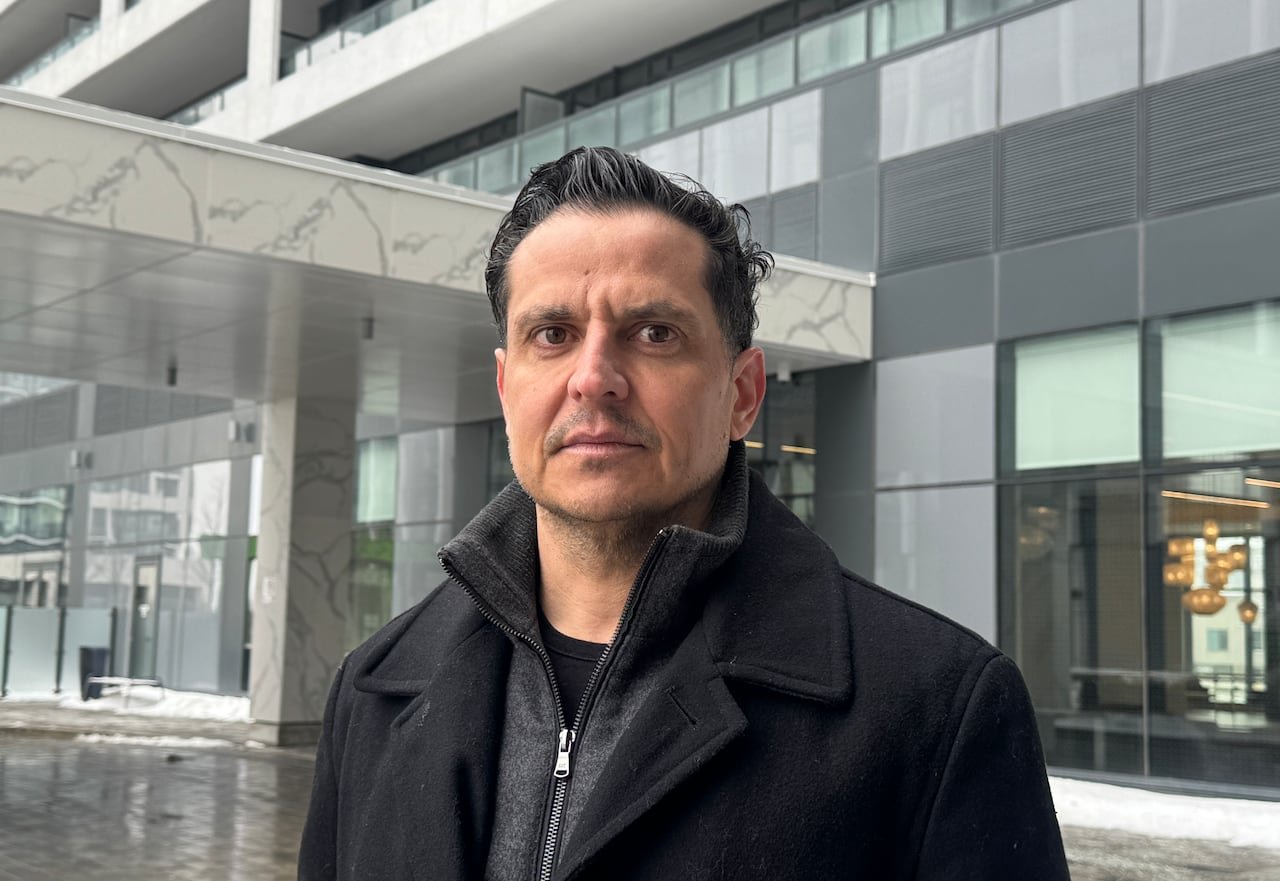 default-403 A man stands in front of a condo building