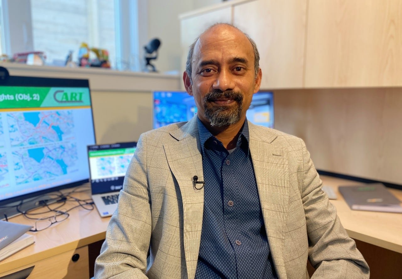 default-318 A man in a suit sits in front of computer screens