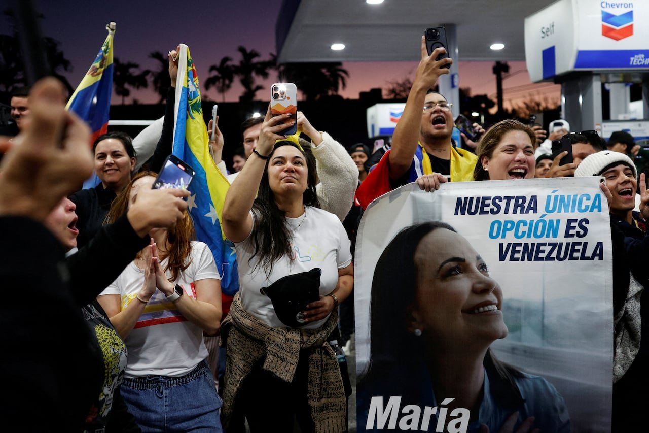 default-11 A woman holds a banner depicting Venezuelan opposition leader Maria Corina Machado