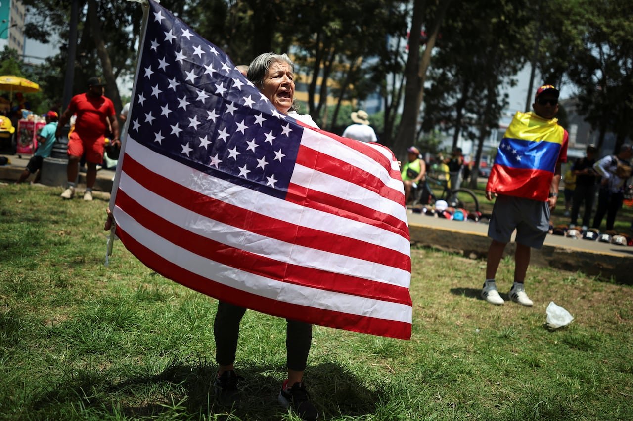default-12 A woman holds a U.S. flag as people gather outside Venezuela's embassy
