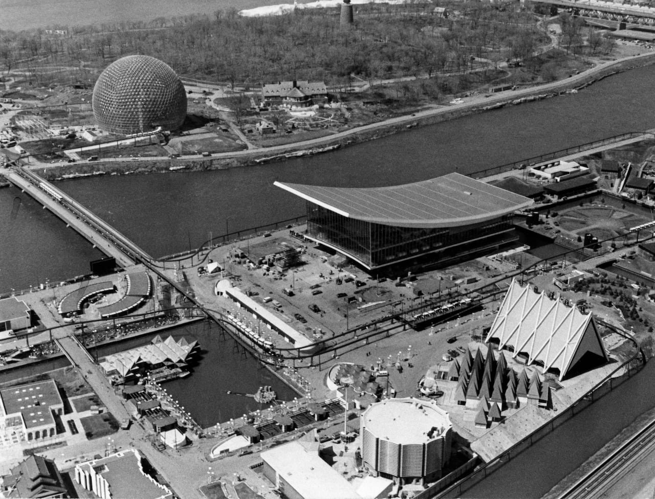 A photo from Expo 67 in Montreal shows an oversized geodesic dome and other buildings on the fair grounds that are separated by a waterway.