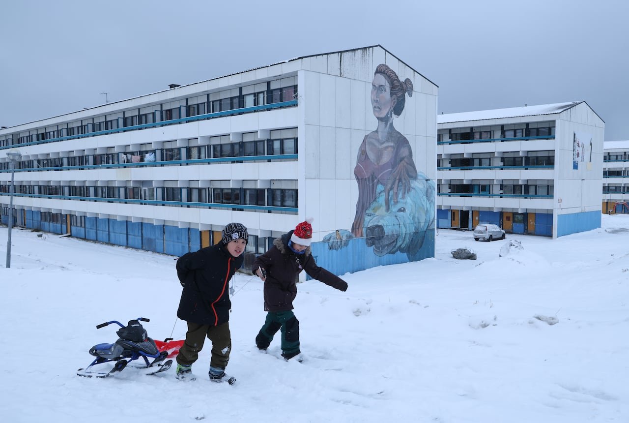 default-644 Two children with a sled next to a residential apartment building.