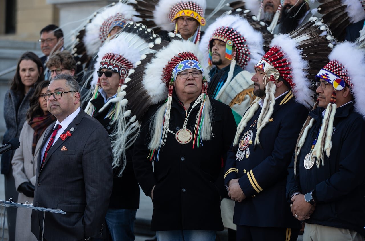 default-744 Men in suits and indigenous headdresses stand shoulder to shoulder