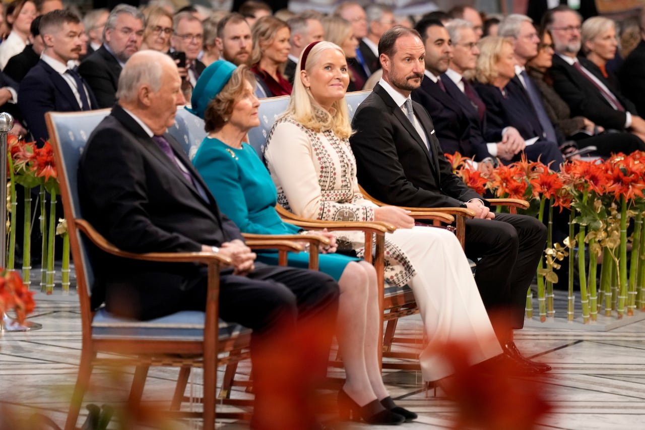 default-246 Four individuals in formal attire seated in a crowd
