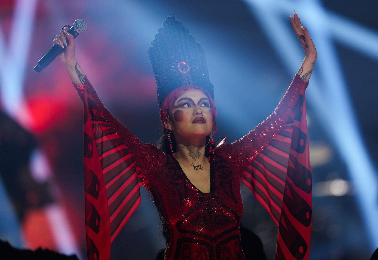 default-489 A performer in red flowing clothing and a tall headwear holds her arms up